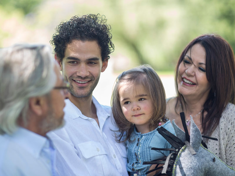 A multi-generational family talking outside