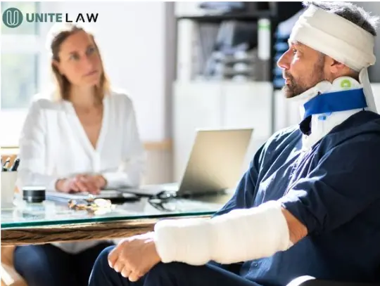 Personal injury lawyer listening to a client in a wheelchair after a car accident